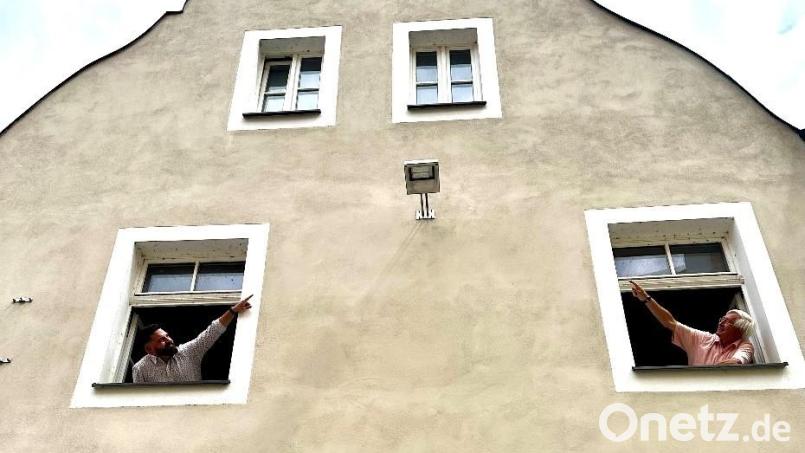 Bürgermeister Sebastian Giering (links) und Energiereferent Karl Meier (rechts) begutachten die erste LED-Stadtlampe am Neustädter Stadtplatz am Haus der Wohnungsbaugesellschaft St. Martin. Bild: Stadt Neustadt/Ramona Herrmann/exb