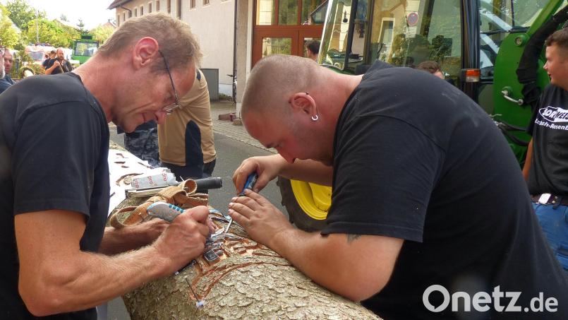 Profis bei der Arbeit: Das Schnitzen der Logos und der Jahreszahl in die Rinde des Kirwa-Baumes ist eine Arbeit für ruhige Hände. Bild: mfh