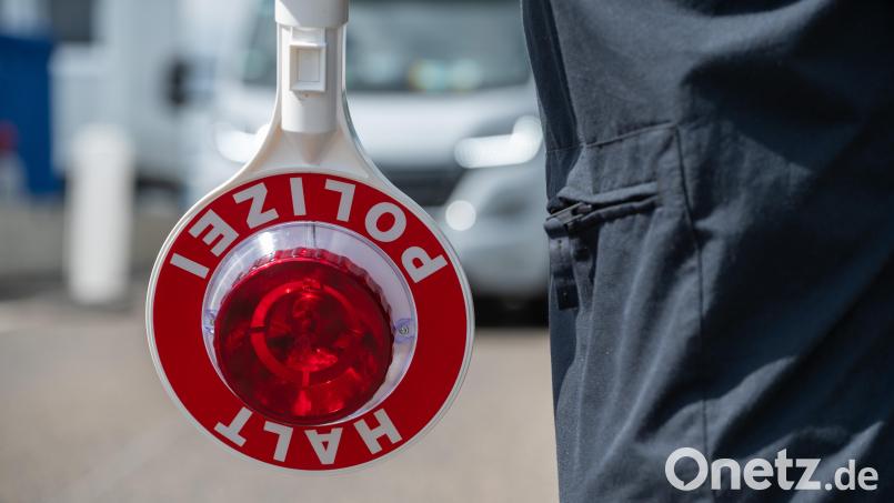 Ein Polizist hält eine Kelle in der Hand. Symbolbild: Harald Tittel/dpa