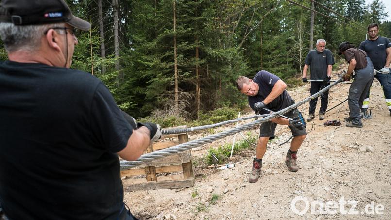Wenn man Krafteinsatz sehen kann: Markus Niedermayr, der Spleißer, sticht mit seinem Spezialwerkzeug ins Seil ein und dreht es gegen den Uhrzeigersinn, um die Litze des Gegenstücks von der Bergseite einzuflechten. Nicht nur er muss sich anstrengen. Auch die, die gegenhalten (oben) und derjenige, der die Stahlseil-Litze mit dreht. Bild: Eric Waha/fph