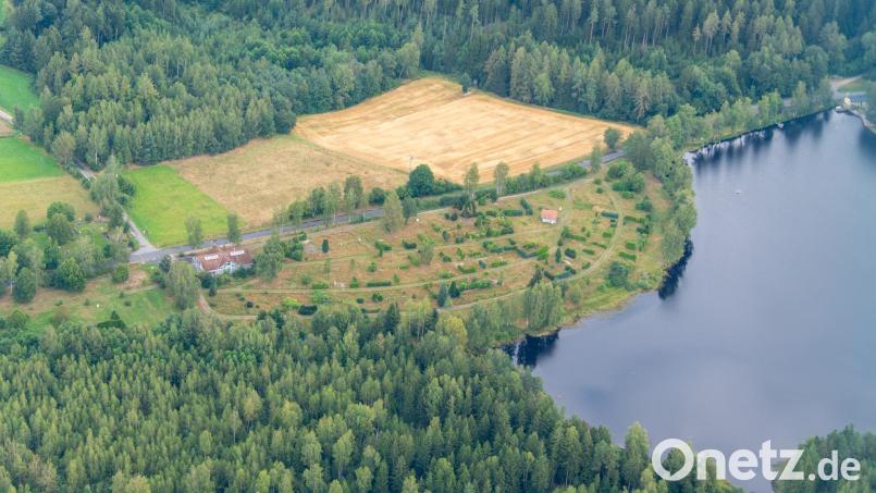 Das über 22.000 Quadratmeter große ehemalige Campingplatz-Gelände in Plößberg ist seit drei Jahren verwaist. Nachdem zwischenzeitlich nach monatelangen Verhandlungen zwei interessierte Bieter für ein neues Konzept abgesprungen waren, gibt es nun neue Interessenten. Luftbild: mür