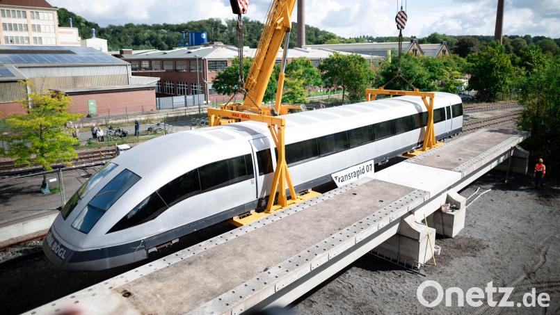Der Transrapid wird vom Tieflader abgeladen und steht vor der zukünftigen Strecke, vorne im Bild. Bochum bekommt den Transrapid. Als neues Exponat wird der Transrapid 07 am Bochumer Eisenbahnmuseum aufgebaut. Das Museum hat das Fahrzeug mitsamt einem Teil seiner Fahrbahn vom Nürnberger Unternehmen Max Bögl, das den Transrapid mitentwickelte, erworben. Bild: Fabian Strauch/dpa