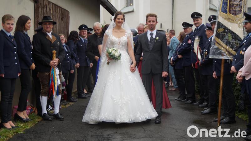 Durch ein Spalier aus Vereinsvertretern schreiten Sandra und Hubert Roth nach der Trauung Bild: wel