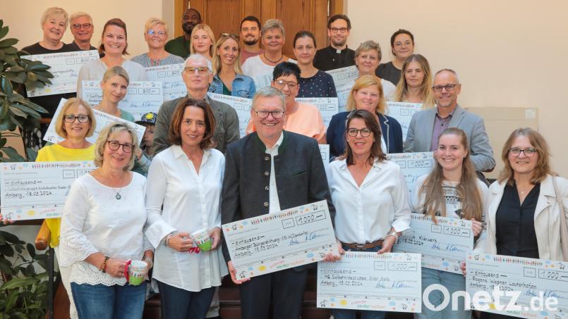 Freudestrahlend präsentieren die Vertreter von 22 Vereinen und Institutionen im Rathaus ihre Spendenschecks, die sie zusammen mit Oberbürgermeister Michael Cerny (vorne Mitte) aus den Händen von Anne Wagner (links neben dem OB) und Katharina Ostermann (rechts von ihm) vom Verein „Amberger Kinder helfen“ entgegennahmen. Bild: Wolfgang Steinbacher
