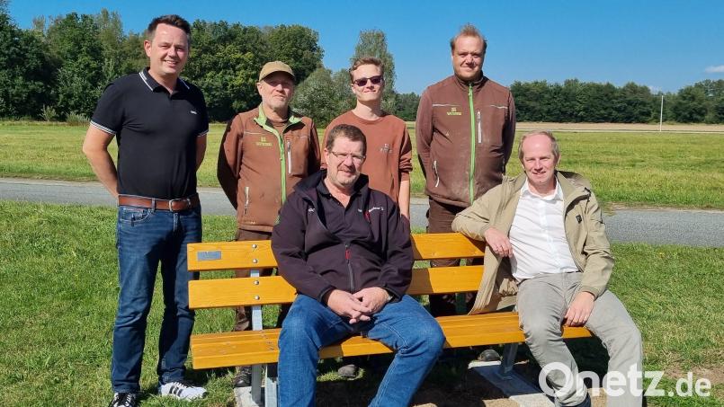 Werkstattleiter Florian Dotzler, Ernst Michael, Pascal Kropp, Thomas Stadler (hinten), Marktrat Dieter Buchner und Bürgermeister Konrad Kiener (vorne) zeigt das Bild auf einer neuen Bank. Bild: Florian Dotzler/exb