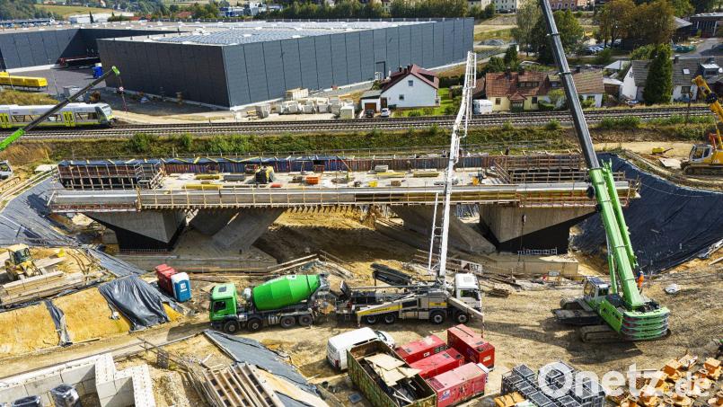 Das Brückenbauwerk mit einer Länge von 63 Metern und einem Gewicht von 4125 Tonnen wird in zwei Etappen unter die Bahnlinie eingeschoben. Bild: Wolfgang Erhart/exb