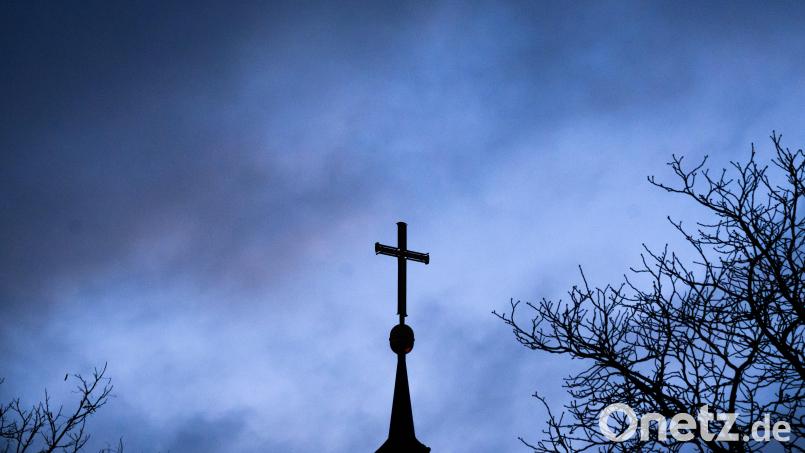 Dunkle Wolken über einer Kirche: Betroffene von sexuellem Missbrauch in der Kirche haben mehrere Anlaufstellen, an die sie sich wenden können. Symbolbild: Julian Stratenschulte/dpa