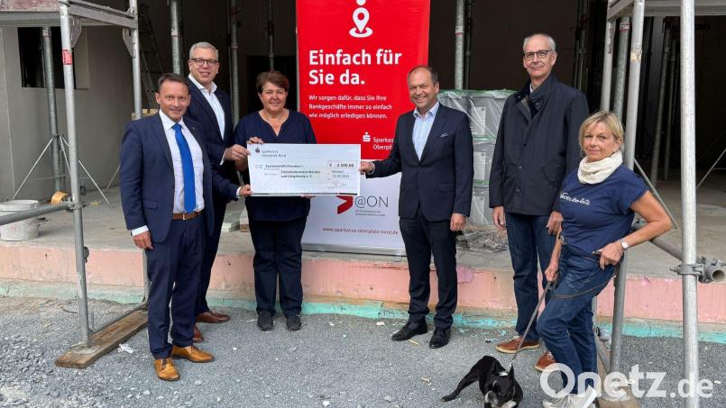 Die Spendenübergabe geht vor der Baustelle des neuen Tierheims über die Bühne. Bild: Martin Stangl
