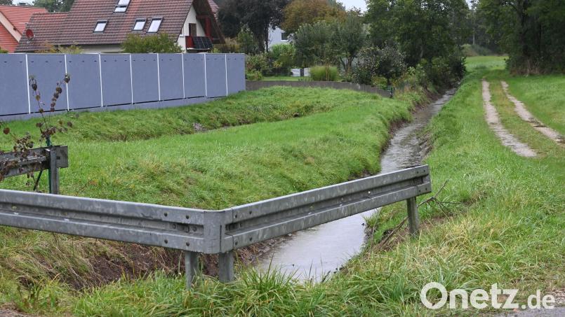 Der Gebenbach ist bis zum Durchlass am Urspringer Weg gesäubert, ebenso das Regenüberlaufbecken (links vor dem Zaun). Im hinteren Bereich jedoch reicht die Bepflanzung bis an den Gebenbach heran, obwohl nach ursprünglichen Planungen diese Fläche entlang des Gebenbachs freizuhalten ist. Bild: gf