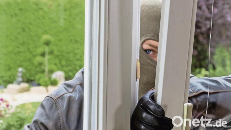 Eine gestellte Szene: Durch ein gekipptes Fenster dringt ein Einbrecher in ein Haus ein. Symbolbild: Erwin Wodicka