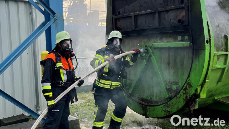 Mit schwerem Atemschutz versuchen die Feuerwehrler beim Übungsszenario beim Müllkraftwerk Schwandorf einen brennenden Container zu kühlen und zu löschen. Bild: Franz Grabinger, ZMS/exb