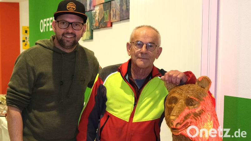 Die Kettensägen-Schnitzer Markus Gietl (links) und Norbert Lehner (rechts) stellen im Mehrgenerationenhaus in Wackersdorf aus. Zu den Exponaten gehört auch dieser Grizzlybär aus Holz. Bild: Hirsch