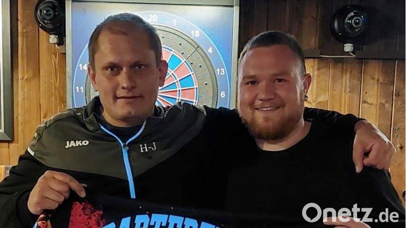 Der Teamcoach Hans-Jürgen Bauer übergibt Julian Burger aus Waldsassen das neue Trikot der Dartfreunde. Bild: gz