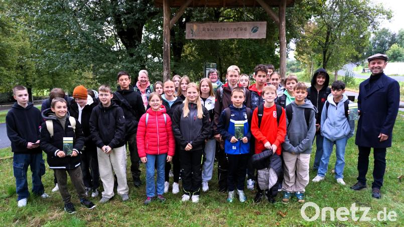 Bürgermeister Hans Ram (rechts), Isabel Lautenschlager (hinten Mitte) und die 7. Klasse der Mittelschule Ensdorf mit Klassenlehrerin Sabine Stopfer-Birner bei der offiziellen Eröffnung des Baumlehrpfads. Bild: tra