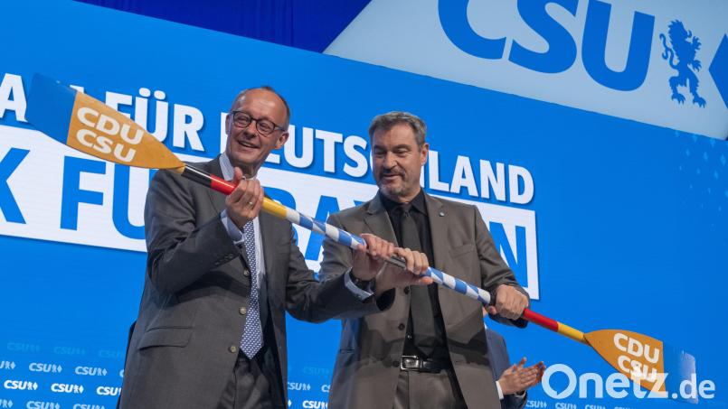 Zwei in einem Boot: Friedrich Merz (links) und Markus Söder mit dem symbolischen Gastgeschenk der CSU an den Parteitagsgast Merz. Bild: Peter Kneffel