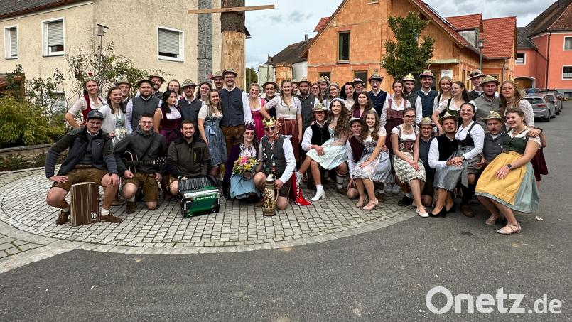 Die 23 Großschönbrunner Kirwapaare mit ihrem neuem Oberkirwapaar Carina Hüttner und Michael Dotzler präsentieren sich vor dem Kirwabaum. Bild: jud