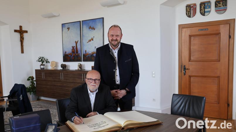Knapp vier Jahre war Harry Grimm (links) Kreisarchivpflegers im Landkreis Neustadt. Landrat Andreas Meier dankte ihm und er durfte sich ins Goldene Buch eintragen. Bild: Landratsamt Neustadt/WN/ Marcel Weidner