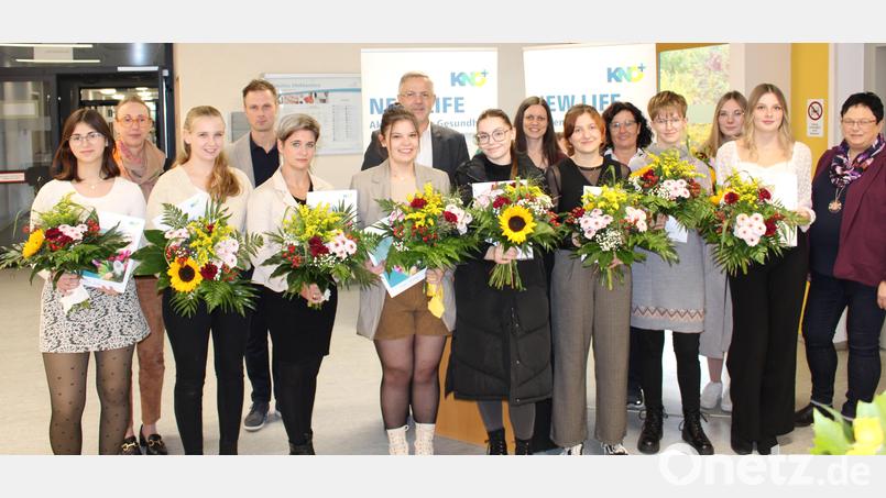 Blumen und Urkunden für Glanzleistungen. Die Staatspreisträgerinnen mit Pflegedirektorin Angela Dzyck (Zweite von links), Schulleiter Matthias Dumler (Vierter von links) und KNO-Vorstand Michael Hoffmann (Siebter von links). Bild: Kliniken Nordoberpfalz. Friedrich Peterhans.