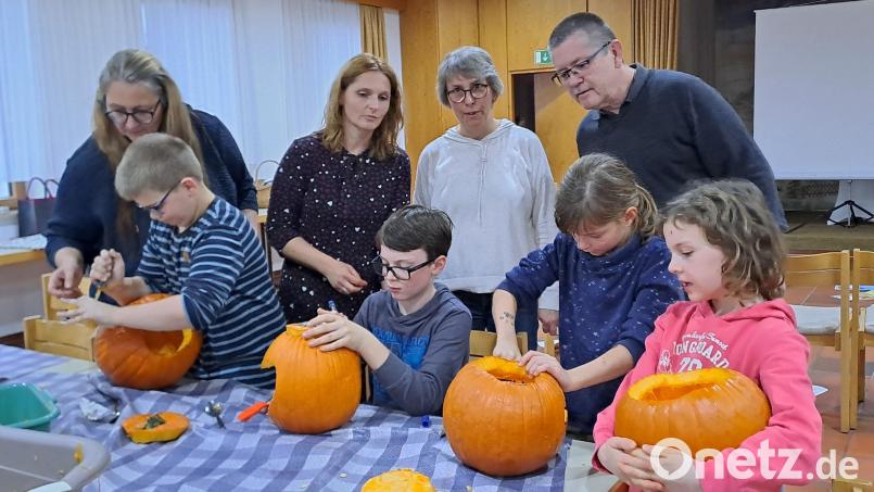 Pfarrer Ferdinand Weinberger (hinten, von rechts), Martina Schinner, Rebecca Kellner und Tatjana Peschek standen den begeisterten Kindern mit Rat und Tat zur Seite beim Kürbisschnitzen. Bild: gis