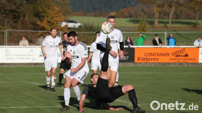Artistische Höchstleistung, wie es sich für ein Kreisliga-Spitzenspiel gehört: Patrick Dittner (vorne) befördert den Ball per Fallrückzieher vor das Tor der SpVgg Schirmitz. Sebastian Treml (Nummer 23) und Michell Pscherer (33) erleben dieses Kunststück aus nächster Nähe. Bild: Dieter Jäschke