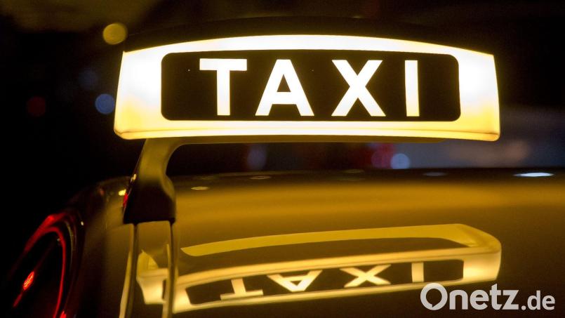 Ein beleuchtetes Taxi-Schild auf einem Autodach. In Amberg saß ein Mann vor Gericht, der einen Taxifahrer beleidigt und beschimpft hatte. Bild: Daniel Karmann/dpa