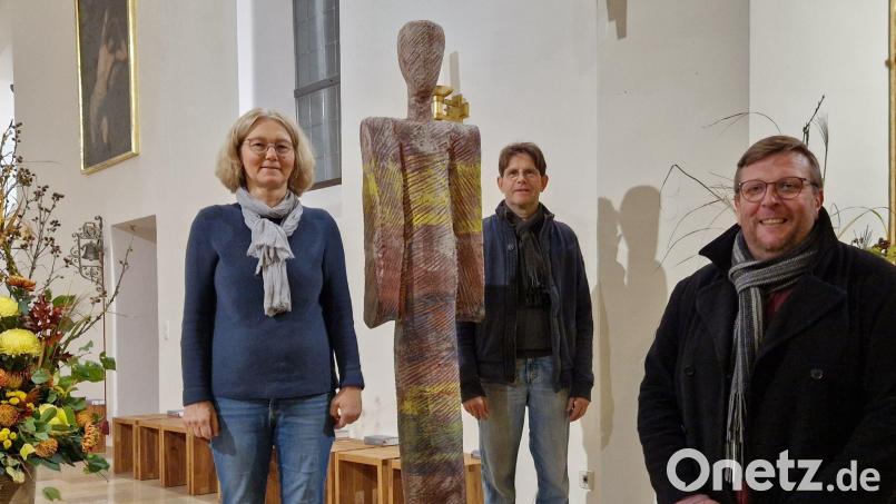 Kunst in der Klardorfer Kirche: "Der Bote" von Michaela Geissler (links), hier mit ihrem Mann Florian Geissler (Mitte) und Pfarrer Markus Meier (rechts), für den die Skulptur einen "Engel der Hoffnung" darstellt. Bild: Dobler