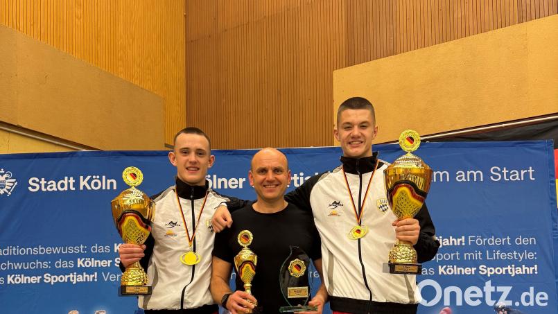 Die Sieger Eric Propp (links) und Dietrich Hermann (rechts) mit ihren Pokalen für den Titel und ihre Leistungen als besten Kämpfer beziehungsweise besten Techniker und ihrem Trainer Ruslan Schönfeld. Bild: Manuel Propp