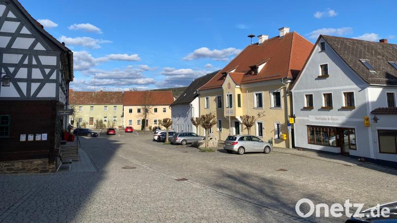 Dieses Jahr steckt die Gemeinde Bad Neualbenreuth viel Geld in den Gigabit- und Mobilfunknetz-Ausbau. Nächstes Jahr soll dann am Marktplatz die Sanierung des Anwesens Nr. 4 (grünes Gebäude im Hintergrund) beginnen. Dort soll der Dorfladen einziehen. Er ist aktuell in einer Übergangslösung (rechts) untergebracht. Bild: Franziska Maier/exb