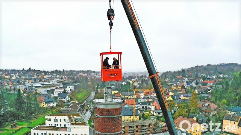 Nur an einem Kranseil baumelnd, können Bezirkskaminkehrermeister Boris Kowalewski (rechts) und sein Geselle Janik Fuchs den 45 Meter hohen Kamin am Benker-Areal in Marktredwitz reinigen. Bild: Stefan Rosenbaum/ESM/exb