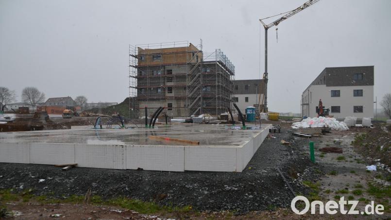 3 der 14 geplanten Mehrfamilienhäuser stehen bereits, bei zweien ist auch die Außenfassade schon angebracht. Für ein viertes Gebäude ist die Bodenpatte gegossen (vorne). Wann die Arbeiten weitergehen, ist derzeit unklar. Die Baustelle ist laut Anwohnern schon seit ein paar Tagen verwaist. Bild: ak