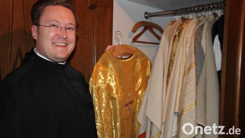 Herr Alexander zeigt sein Primizgewand im Schrank seiner Priesterkleider. Bild: kro