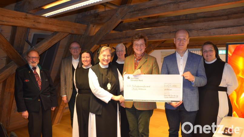 Klosterfreunde-Vorsitzende Monika Hohlmeier und Schatzmeister Thomas Böhm (Dritte und Zweiter von rechts) überreichten den symbolischen 25.000-Euro-Scheck. Von links Bruno Salomon und Gerhard Heindl vom Förderverein sowie Sr. Raphaela Kratzer, Äbtissin Laetitia Fech, Sr. Agnes Richter und rechts Priorin Sr. Sophia Schlembach. Bild: pz