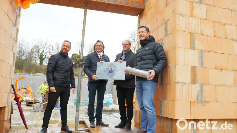 Bürgermeister Jörk Kaduk (rechts) bringt die Büchse mit Plänen, Bauantrag und der Tageszeitung zur Grundsteinlegung. Zeugen sind (von links) Landtagsabgeordneter Bernhard Heinisch, Architekt Wolfgang Brummer und Jürgen Pickel von der Baufirma. Bild: gru