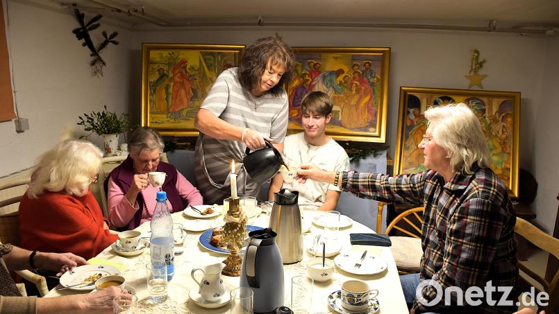 Diesmal hat sich Olga Luft (stehend) Künstler Tom Brankovic (rechts) ins Haus geholt. Er stellt drei seiner großflächigen Bibelbilder aus. Zur Auftaktveranstaltung spielte Simeon Franz (Zweiter von rechts.) für die Gäste am Akkordeon. Bild: ubb