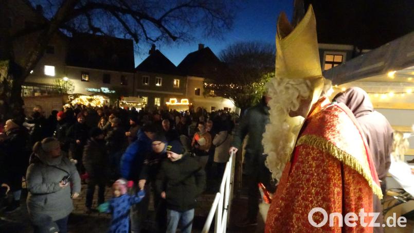 Sankt Nikolaus hat für die jüngsten Marktbesucher kleine Geschenke dabei. Diesen Moment wollen auch die Eltern nicht verpassen. Bild: hm