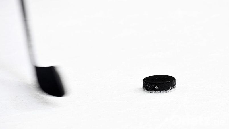 Ein Puck und ein Eishockeyschläger. Bild: Tobias Hase/dpa/Archivbild