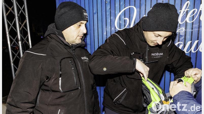 Moritz Huber (rechts) und sein Kollege Al-Rabati Hawkar vom Sicherheitsdienst &quot;Novum&quot; kontrollieren auf dem Schwandorfer Weihnachtsmarkt einen Rucksack. Bild: Hösamer