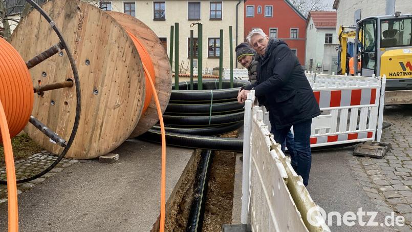 Leitungsbau in der Dorfstraße: Norbert Arnold und Hans Bäumler schauen auf der Baustelle nach dem Rechten. Schwarz ist die Leitung für die Nahwärme, orangefarben für Glasfaser. Bild: upl