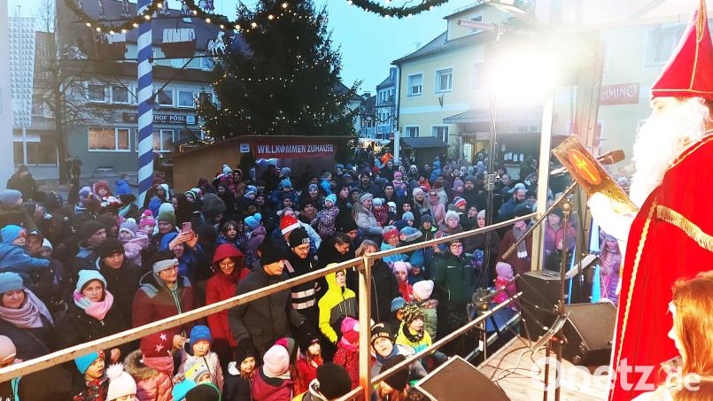 Der Nikolaus ist endlich da. Er verteilt mit seinen Helferinnen 500 Päckchen an die Kinder, die dichtgedrängt mit ihren Eltern den Marktplatz bevölkern. Bild: lg