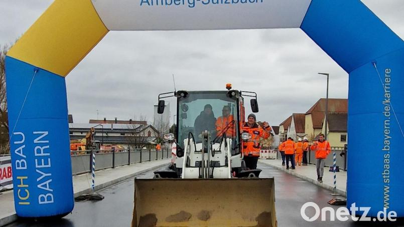 Bürgermeister Peter Neumeier hat als Führer des Laders zusammen mit Hannes Neudam und dem &quot;Gesicht der Brückenbaustelle&quot;, Elisabeth Weiß, das letzte Baufahrzeug von der Brücke wegbewegt und die Brücke somit für den Verkehr freigegeben. Bild: mab