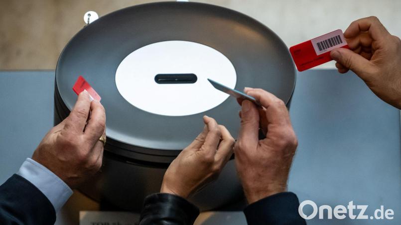 Abgeordnete werfen im Bundestag ihre Stimmkarte ein. Symbolbild: Michael Kappeler/dpa
