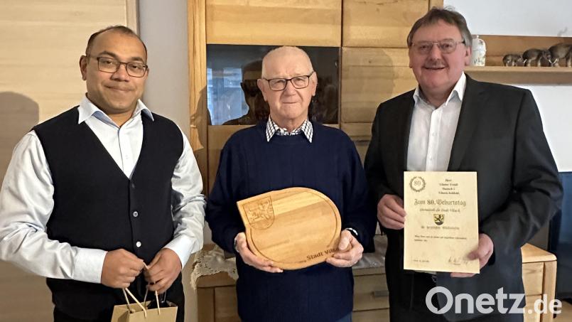 Bürgermeister Hans-Martin Schertl (rechts) und Pater Jimmy (links) überbringen dem Jubilar Günter Troidl die Glückwünsche zum 80. Geburtstag. Bild: Stefanie Gradl