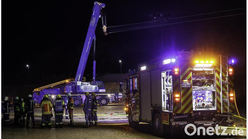 Der Haken eines mobilen Schwerlastkrans hat sich am Montagabend in einer Hochspannungsleitung im Stullner Industriegebiet verfangen. Die Einsatzkräfte von Feuerwehr und THW warten darauf, dass der Strom sicher abgeschaltet wird und sie eingreifen können. Bild: Hösamer