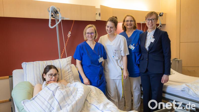 Hebamme Stefanie Lang, stellvertretende Stationsleiterin Anna Prey, Oberärztin Iris Rothenbacher und Janina Philipp, die Geschäftsführerin des Krankenhauses (stehend, von links) gratulieren der jungen Mutter. Bild: Michael Vogl/exb