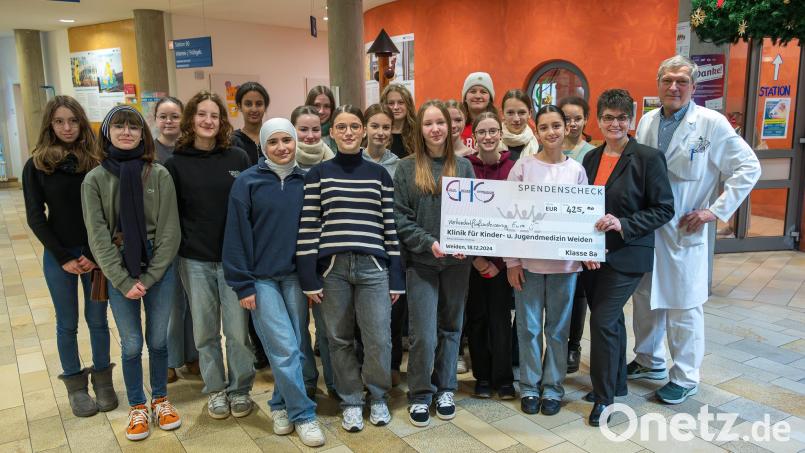 Die 8a des Elly-Heuss-Gymnasiums beweist soziales Engagement. Sie überreicht 425 Euro für die Kinderklinik Weiden. Darüber freuen sich besonders (von rechts) Chefarzt Dr. Fritz Schneble und Manuela Humig aus der Pflegedirektion. Bild: Martin Kuhn, Elly-Heuss-Gymnasium