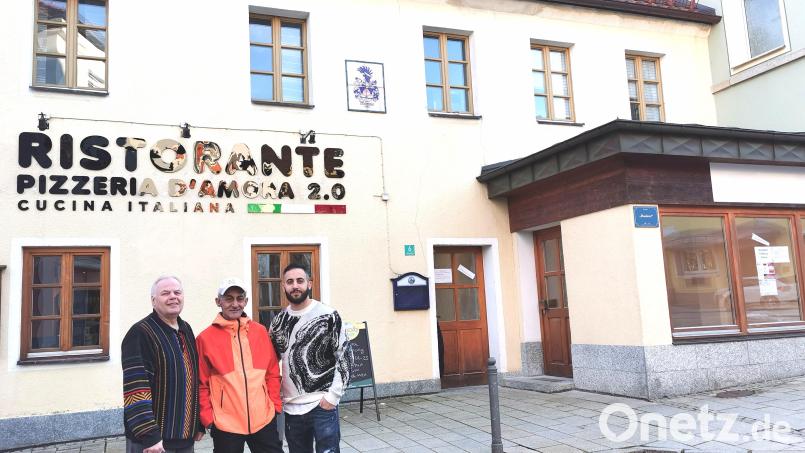 Neuer Schriftzug für die neue Pizzeria am Marktplatz 6 in Oberviechtach: Michael Welnhofer (links) freut sich über den neuen Pächter Domenico D’ Amora (rechts) und dessen Vater Francesco. Der frühere Bäckereiladen (rechts) wird zum Hauptraum der Gastronomie. Bild: Portner