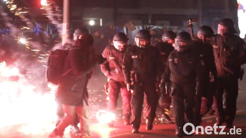 Polizei zwischen brennendem Feuerwerk auf der Straße in Berlin in der Silvesternacht. Bild: Julius Schreiner/dpa