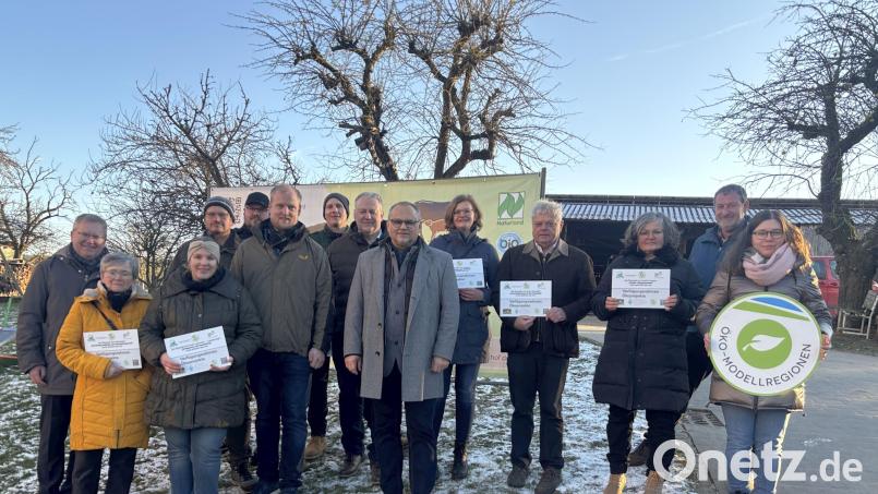 Die Preisträger erhielten bei einer Feier auf dem Lobenhof in Steiningloh Förder-Schilder der Öko-Modellregion, hier mit den Gratulanten, darunter Projektmanagerin Annika Reich (rechts). Bild: ge