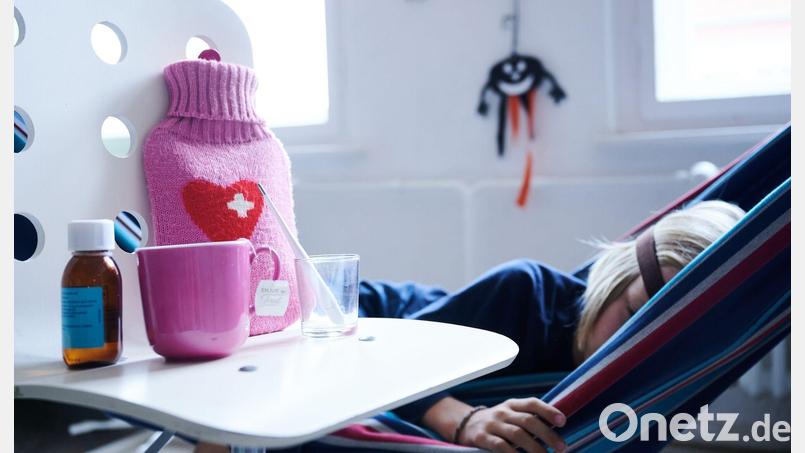 Fieberthermometer, Hustensaft, Wärmflasche und eine Tasse Tee: Wegen der aktuellen Grippewelle liegen viele Kinder und Jugendliche flach. Symbolbild: Annette Riedl/dpa