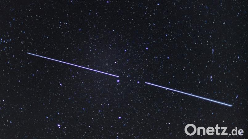 Ein &quot;Starlink&quot; ist eine Aneinanderreihung von Satelliten. Bei günstigen Bedingungen sind diese Lichtstreifen am Nachthimmel zu sehen. Symbolbild: Patrick Pleul, dpa